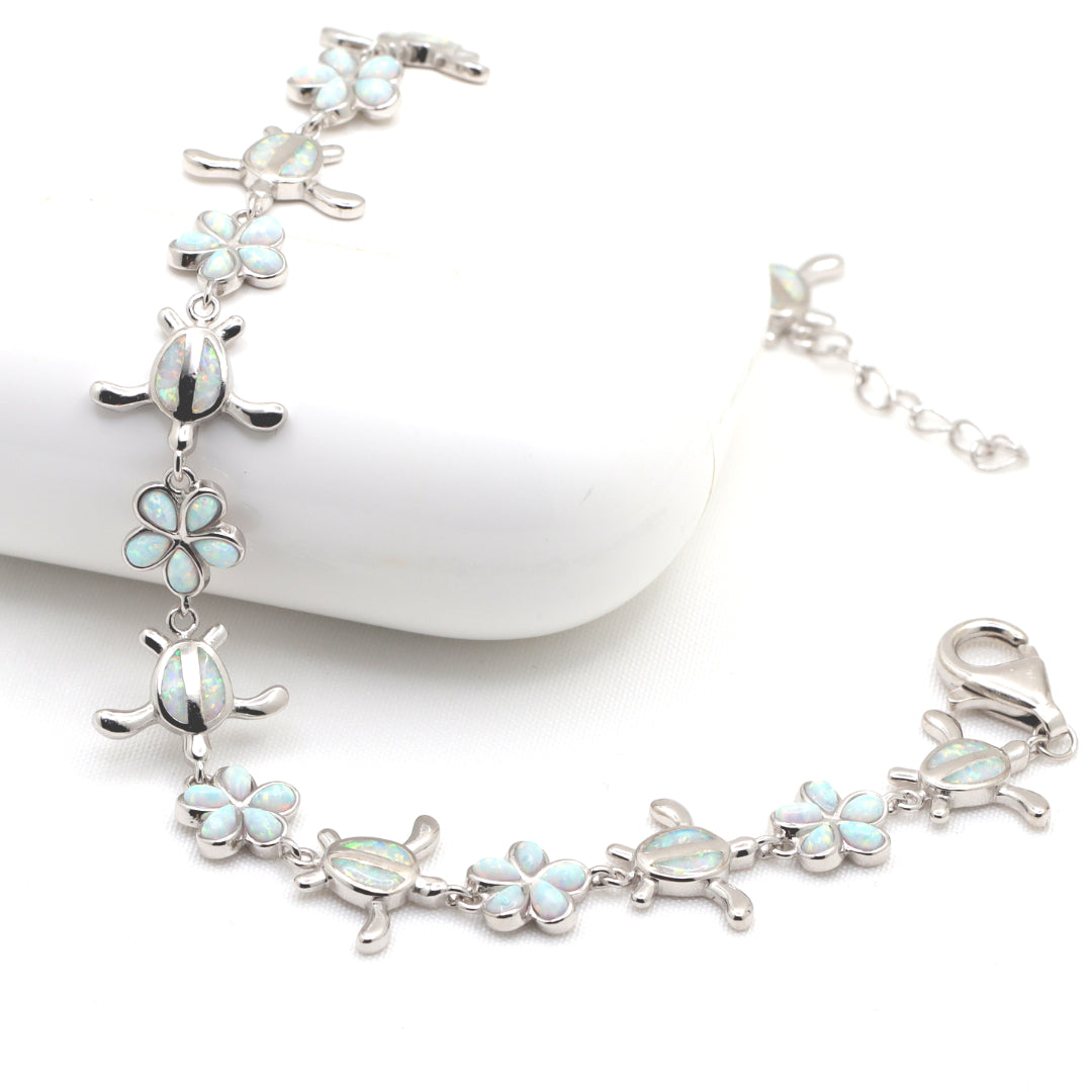 Sterling silver bracelet with sea turtle and flower charms.